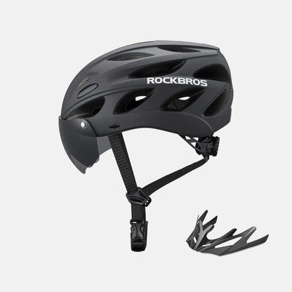 Black bike helmet with dark visor, adjustable chin strap, and included goggles accessory