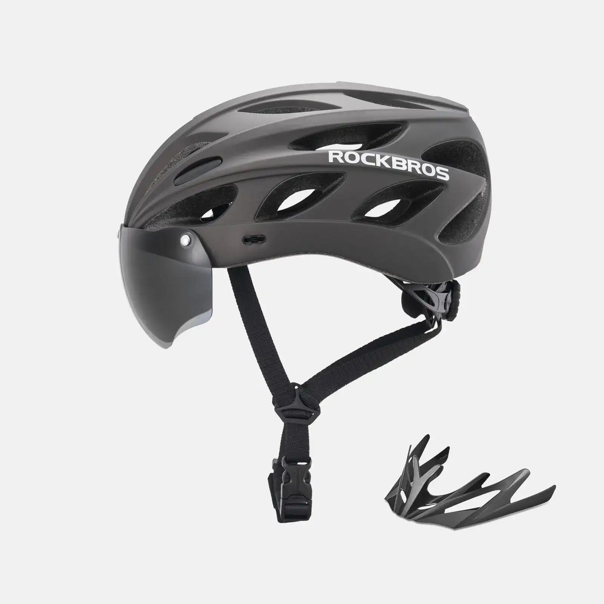 Gray bike helmet with dark visor and adjustable chin strap, shown with goggles accessory