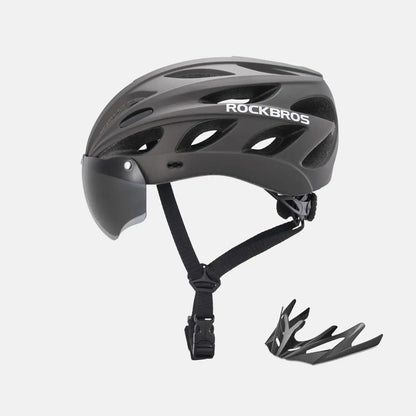 Gray bike helmet with dark visor and adjustable chin strap, shown with goggles accessory