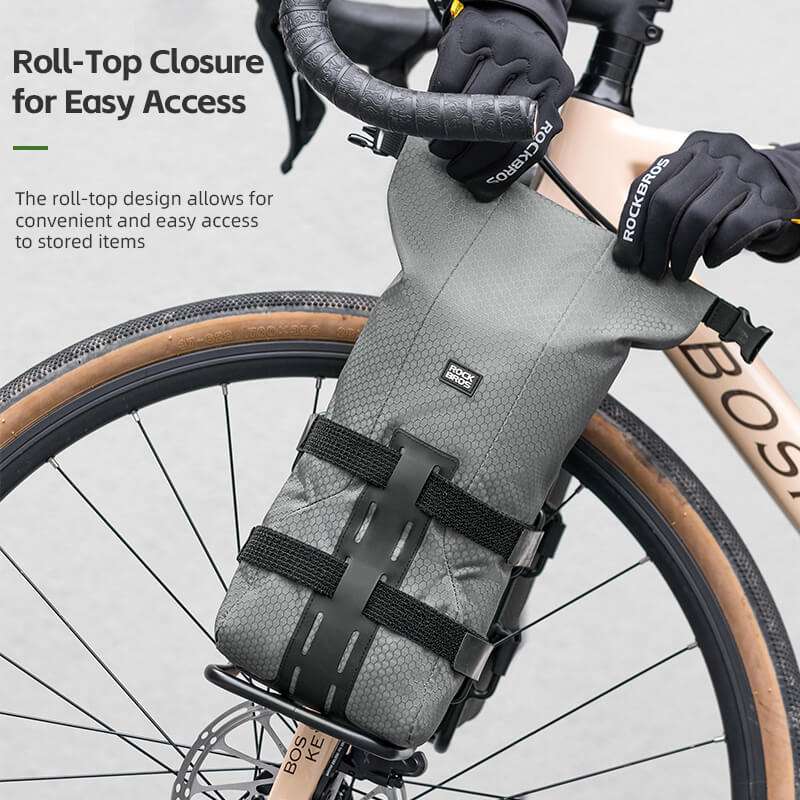 Gray roll-top front fork rack bag mounted on a bicycle fork with securing straps