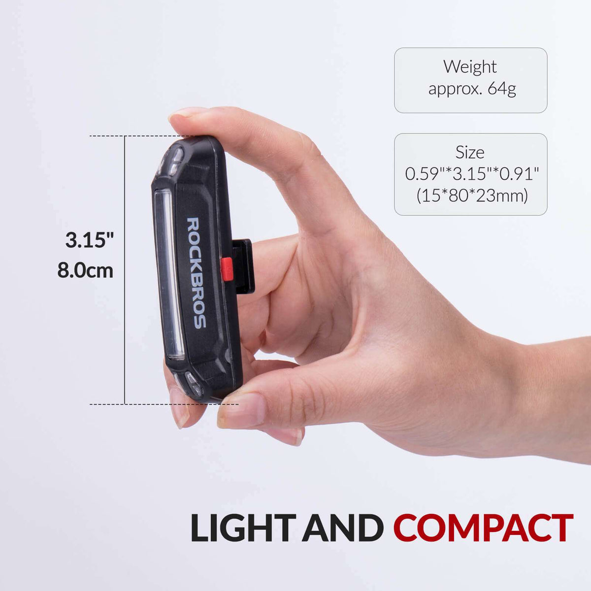 Compact rechargeable rear bike light in hand, black body with red lens accent