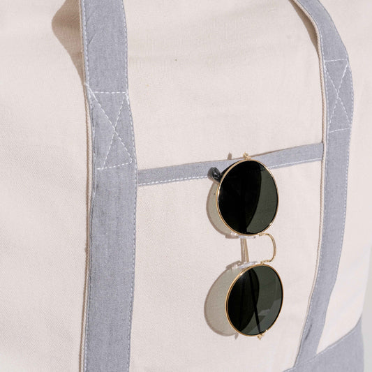 Extra large canvas tote bag with gray-trimmed front pocket and two sunglasses charm
