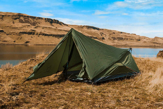 Olive green 1-person backpacking tent with front vestibule and guy lines