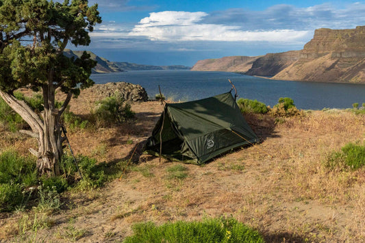 Olive green ultralight 2-person trekking tent with taut fly and stakes
